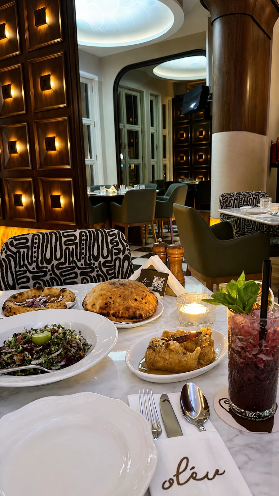A shared OLEV table with breads, mezze and charcoal-grilled plates